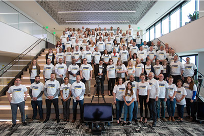 Employees wearing white t-shirts standing in a group photo