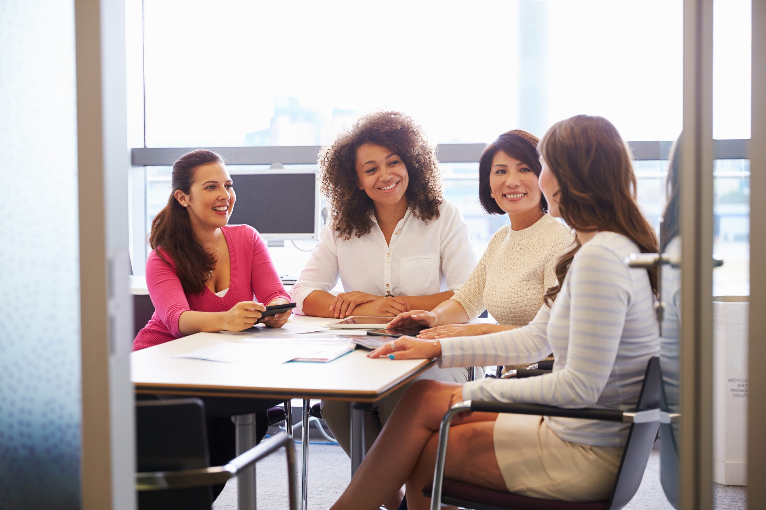 Casually,Dressed,Female,Colleagues,Talking,In,A,Meeting,Room Two people shaking hands